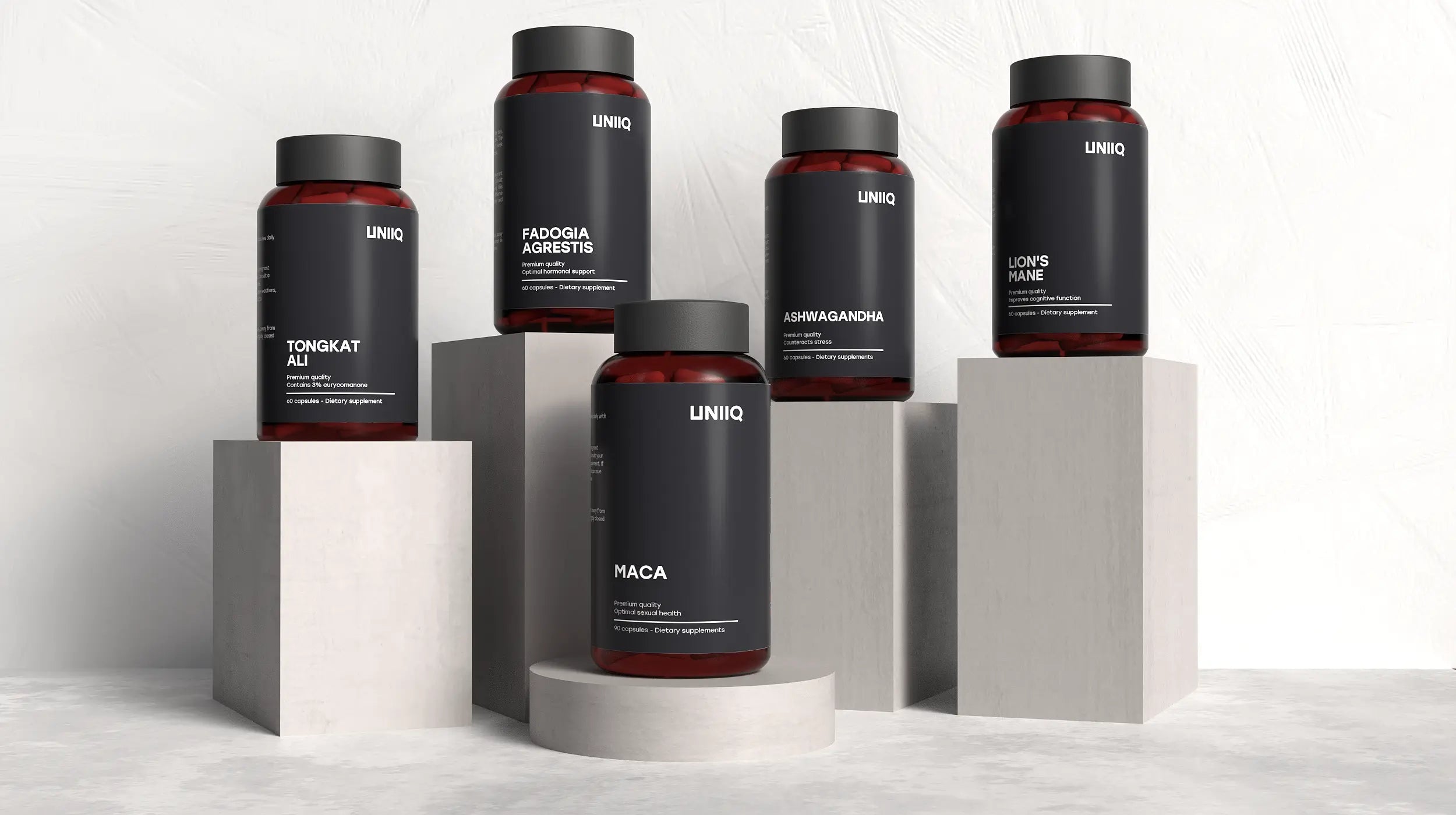 Collection of UNIQ supplement bottles on geometric podiums against a light background